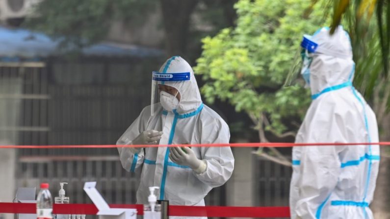 Des travailleurs médicaux portant des équipements de protection attendent que des personnes soient testées pour le nouveau coronavirus Covid-19 dans un quartier de Wuhan, dans la province centrale du Hubei en Chine, le 15 mai 2020. (Hector Retamal/AFP via Getty Images)