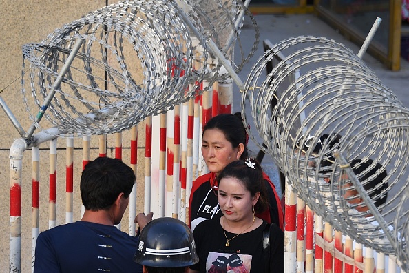 Une femme ouïghoure passe par l’entrée d'un bazar à Hotan, dans la région du nord-ouest du Xinjiang en Chine. Une région chinoise dont la minorité ouïghoure est camouflée par la surveillance et les détentions massives. (Photo : GREG BAKER/AFP via Getty Images)