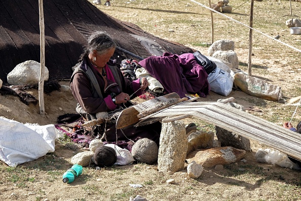 -Un nomade Changpa tisse de la laine de pashmina dans un camp, à environ 1 km du village de Korzok, dans le district de Leh au Ladakh. Photo de NOEMI CASSANELLI / AFP via Getty Images.