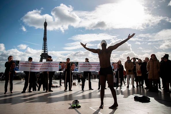 -L'artiste sénégalais Alioune Diagne s'exécute sur l'esplanade du Trocadéro près de la Tour Eiffel à Paris, le 11 février 2020, lors d'un rassemblement en soutien à l'universitaire franco-iranienne Fariba Abdelkhah et à l'universitaire français Roland Marchal, détenus en Iran depuis le 5 juin 2019. Photo de Thomas SAMSON / AFP via Getty Images.