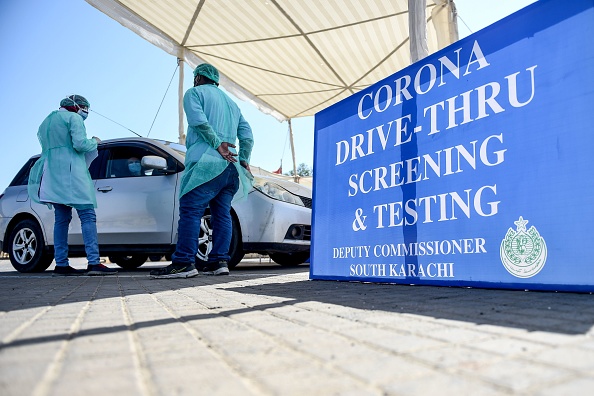 -Dans le port de Karachi le 4 avril 2020, la première installation de dépistage des coronavirus au volant a été établie par le gouvernement provincial du Sindh, ce qui permet aux patients suspectés de coronavirus de se faire tester sans avoir à attendre dans de longues files d'attente. Photo de Rizwan TABASSUM / AFP via Getty Images.