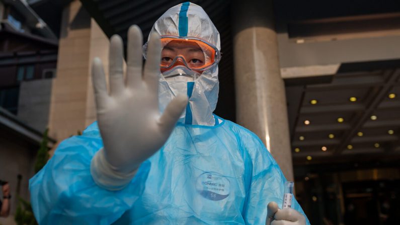 Un professionnel de la santé portant un équipement de protection complet fait des gestes alors qu'il s'apprête à prélever des échantillons par écouvillonnage sur un journaliste (qui n'est pas sur la photo) pour le soumettre au test du Covid-19 à l'hôtel Diaoyutai à Pékin, en Chine, le 28 mai 2020. (Nicolas Asfouri/AFP via Getty Images)