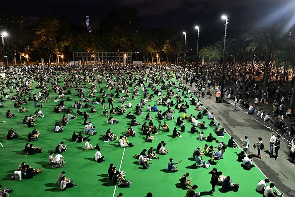 -Les militants tiennent un souvenir aux chandelles à l'extérieur du Victoria Park à Hong Kong le 4 juin 2020, après qu'une veillée annuelle qui a traditionnellement lieu dans le parc pour marquer la répression de 1989 sur la place Tiananmen a été interdite. Photo par ANTHONY WALLACE / AFP via Getty Images.