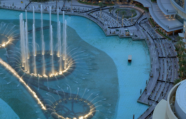 -Les gens observent une distanciation sociale lors d’un rassemblement pour regarder le spectacle de la fontaine de Dubaï, qui reprend depuis que l'émirat du Golfe émerge d'un verrouillage imposé, le 5 juin 2020. Photo de Karim SAHIB / AFP via Getty Images.