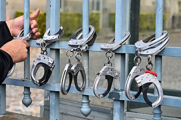 Des policiers attachent leurs menottes à la préfecture de Rennes pour protester contre les annonces du ministre de l'Intérieur (DAMIEN MEYER/AFP via Getty Images)