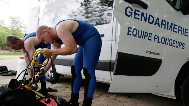 Illustration - Des plongeurs de la Gendarmerie en combinaison de plongée (Photo credit should read KENZO TRIBOUILLARD/AFP via Getty Images)