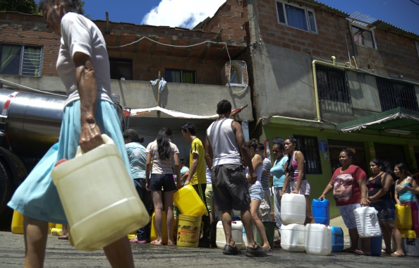 -Jorge Ariza, un paysan déplacé par le conflit armé, recueille de l'eau dans sa maison construite avec des matériaux recyclés à Ciudad Bolivar, au sud de Bogota, le 26 mai 2020. Photo de Raul ARBOLEDA / AFP via Getty Images.