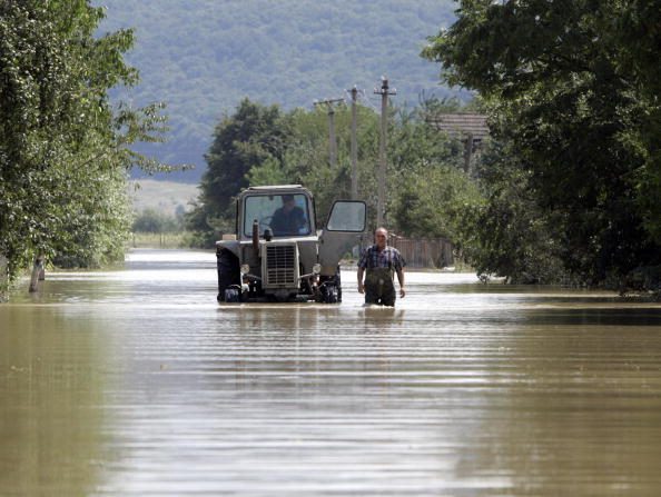 -Illustration- Un homme marche dans une rue submergée après des inondations dans le village de Poberezhya, elles sont plus massives que celles de 2008. Photo MYSHKO MARKIV / AFP / Getty Images.