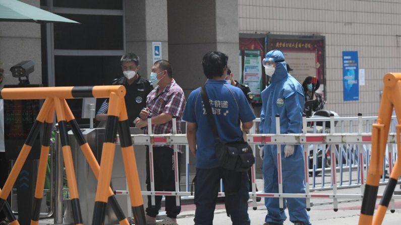 Un personnel de sécurité portant une combinaison de protection monte la garde dans une zone résidentielle fermée près du marché de Yuquan East à Pékin, en Chine, le 15 juin 2020. (NOEL CELIS/AFP via Getty Images)
