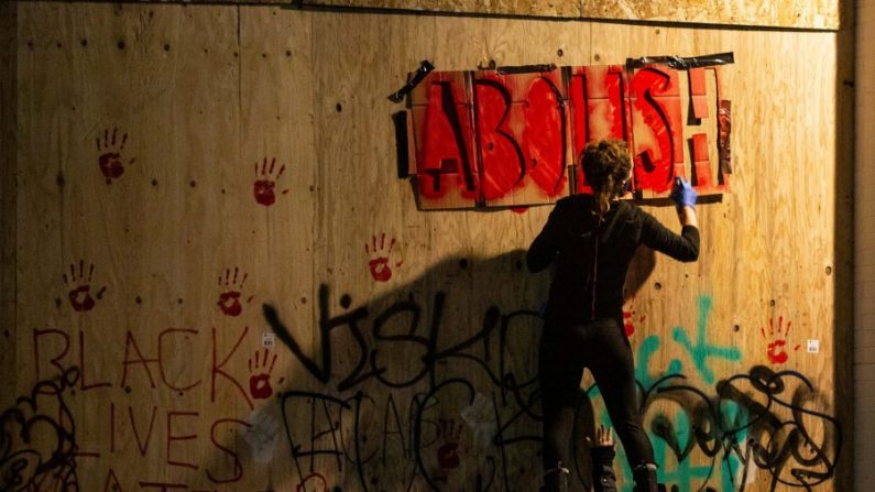 Une personne peint l'extérieur du commissariat Est de la police de Seattle à Seattle, dans l'État de Washington, le 9 juin 2020. (David Ryder/Getty Images) 