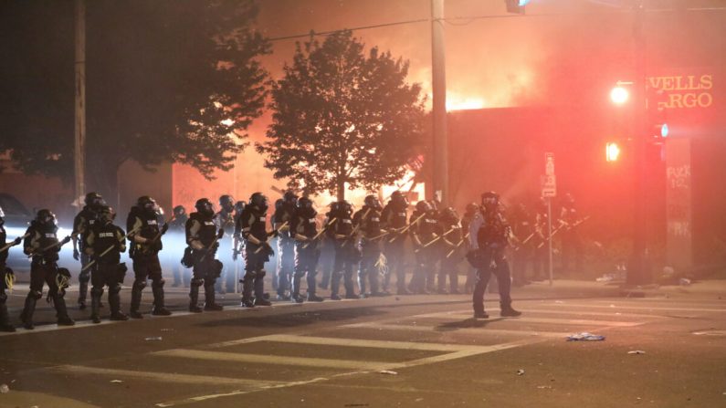 La police reprend les rues vers minuit après avoir tiré de grandes quantités de gaz lacrymogènes pour disperser les manifestants et les émeutiers devant le 5e commissariat de police de Minneapolis, lors de la quatrième nuit de manifestations et de violences qui a suivi la mort de George Floyd, à Minneapolis (Minn.), le 29 mai 2020. (Charlotte Cuthbertson/The Epoch Times)