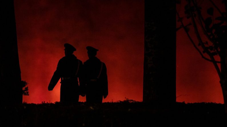 Des agents de la police paramilitaire marchent le long d'un mur rouge près de la porte de Tiananmen à Pékin le 13 novembre 2019. (NOEL CELIS/AFP via Getty Images)