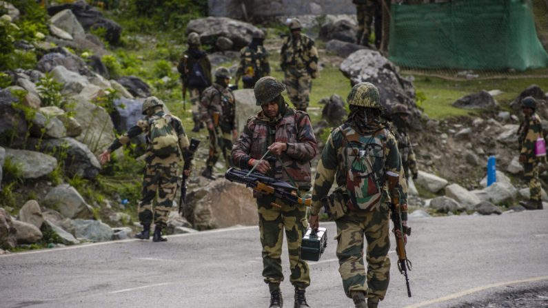 Des soldats de la Force de sécurité frontalière indienne (BSF) patrouillent sur une autoroute lors du passage d'un convoi de l'armée indienne sur une route menant vers Leh, à la frontière chinoise, à Gagangir, en Inde, le 19 juin 2020. (Yawar Nazir/Getty Images)