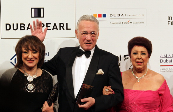 -L'acteur égyptien Izzat Abul Auf pose pour une photo avec sa collègue actrice et ex-mannequin Ragaa al-Giddawi et un invité le 19 décembre 2010. Photo KARIM SAHIB / AFP via Getty Images.