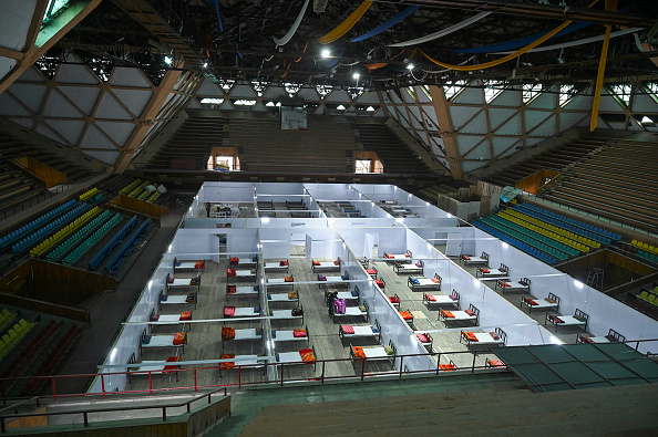 -Illustration- Un employé prépare un lit dans un stade couvert transformé en centre de quarantaine lors d'un verrouillage national imposé par le gouvernement comme mesure préventive contre la propagation du coronavirus le 20 avril 2020. Photo de TAUSEEF MUSTAFA / AFP via Getty Images.