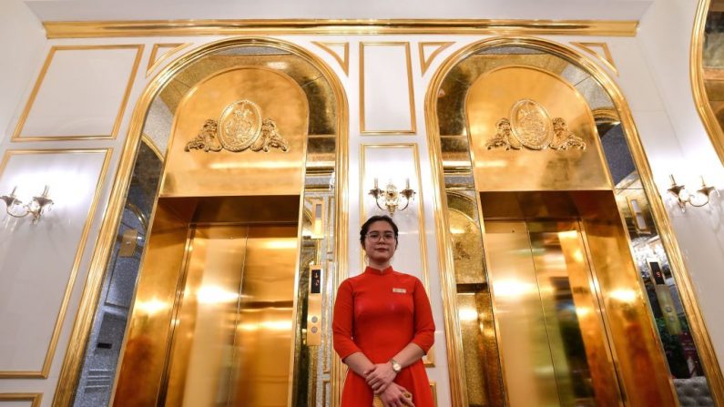 Un membre du personnel de l'hôtel Dolce Hanoi Golden Lake, le premier hôtel plaqué or au monde, à Hanoi (Photo by MANAN VATSYAYANA/AFP via Getty Images)