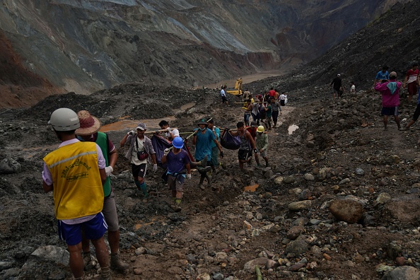 -Des sauveteurs récupèrent des corps près de la zone de glissement de terrain sur le site minier de jade à Hpakant dans l'État de Kachin le 2 juillet 2020. Photo par Zaw Moe Htet / AFP via Getty Images.