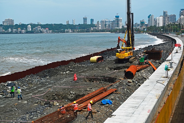 -Des travailleurs sur un chantier de construction d'une route côtière à Mumbai le 21 juillet 2020. Photo de Punit PARANJPE / AFP via Getty Images.