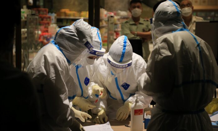 Des travailleurs de la santé effectuent des tests Covid-19 dans un centre commercial à Dalian, dans la province du Liaoning, dans le nord-est de la Chine, le 25 juillet 2020. (STR/AFP via Getty Images)
