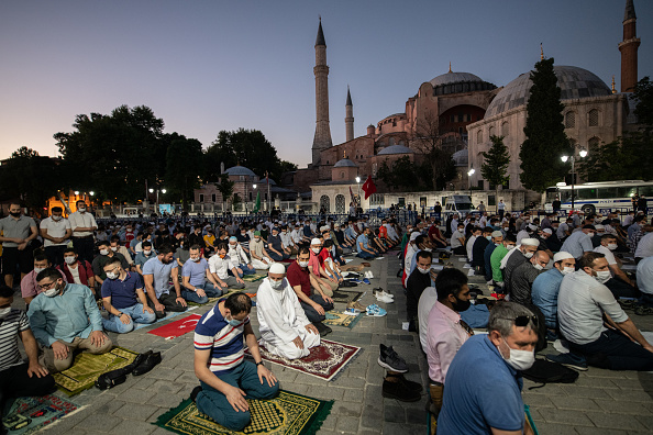 -Les gens se rassemblent pour les prières du soir devant la célèbre basilique Sainte-Sophie d'Istanbul le 10 juillet 2020 à Istanbul, en Turquie. Le gouvernement ouvrira la basilique Sainte-Sophie d'Istanbul au culte le 24 juillet. Photo par Burak Kara / Getty Images.