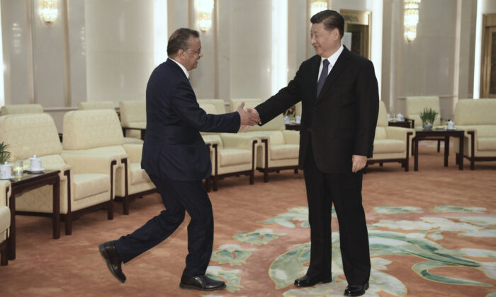 Tedros Adhanom Ghebreyesus, directeur général de l'Organisation mondiale de la santé (à g.), serre la main du chef du régime chinois Xi Jinping avant leur rencontre au Grand palais du Peuple à Pékin, le 28 janvier 2018 . (Naohiko Hatta - Pool/Getty Images)