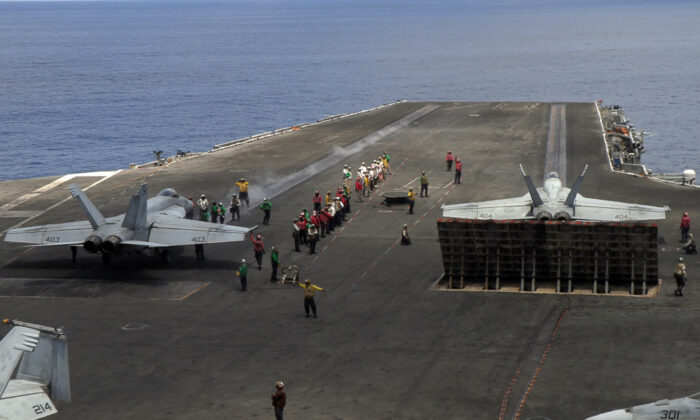 Les chasseurs multirôles F/A-18 Super Hornets de l'US Navy se préparent à décoller du pont d'envol du porte-avions USS Ronald Reagan (CVN-76) le 16 octobre 2019, alors qu'il navigue dans la mer de Chine méridionale en direction de Singapour. (Catherine Lai/AFP via Getty Images)