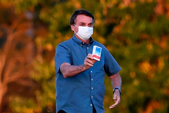 Le Président brésilien Jair Bolsonaro montre une boîte d'hydroxychloroquine à ses partisans devant le palais Alvorada à Brasilia, le 23 juillet 2020. (Photo : EVARISTO SA/AFP via Getty Images)