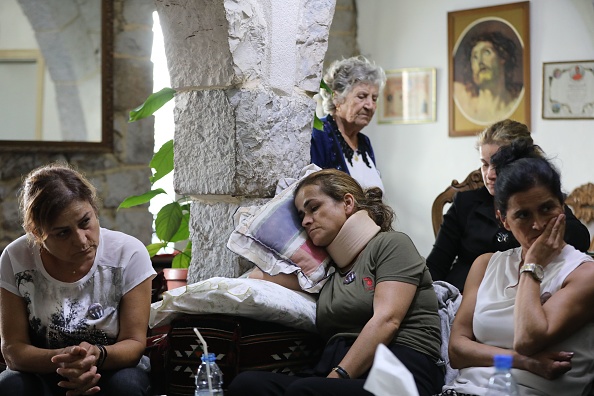 -Des proches se rassemblent autour de Rita Hitti, mère du pompier disparu Najib, 27 ans, dans la ville de montagne de Qartaba, au nord de la capitale libanaise, le 10 août 2020. Photo par ANWAR AMRO / AFP via Getty Images.