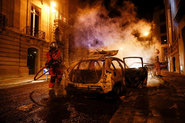 Paris le 23 août 2020. Des pompiers éteignent une voiture en feu près des Champs-Élysées, alors que les supporters du PSG se sont  rassemblés après la finale de la Ligue des champions de l'UEFA entre le Paris Saint-Germain et le Bayern Munich au stade de la Luz à Lisbonne. (Photo : SAMEER AL-DOUMY/AFP via Getty Images)