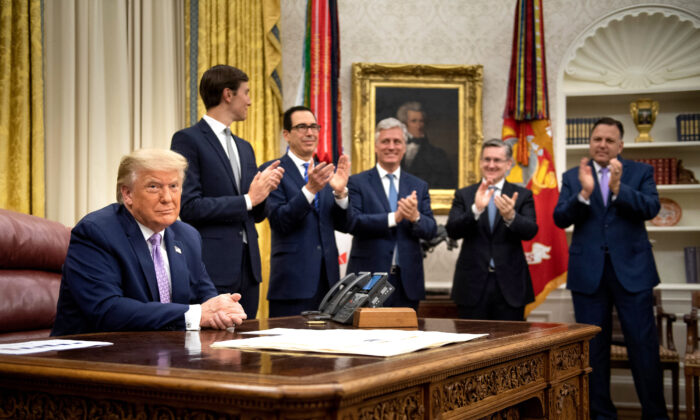 (Debout de g. à d.) Le conseiller principal du président américain Jared Kushner, le secrétaire au Trésor Steven Mnuchin, le conseiller à la sécurité nationale Robert O'Brien et d'autres applaudissent Donald Trump après qu'il a annoncé un accord de normalisation des relations diplomatiques entre les Émirats arabes unis et Israël, à la Maison-Blanche, le 13 août 2020. (Brendan Smialowski/AFP via Getty Images)