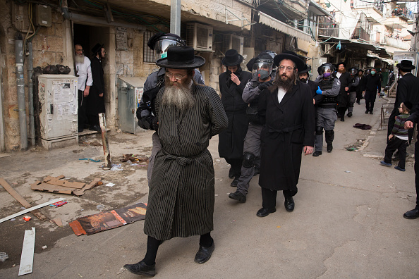 -Illustration- Les troupes de la police israélienne arrêtent des hommes juifs ultra-orthodoxes alors qu'ils appliquent un verrouillage partiel du coronavirus dans le quartier de Mea Shearim à Jérusalem, Israël. Photo par Amir Levy / Getty Images.