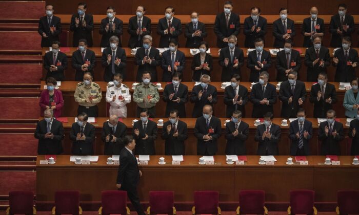 Le dirigeant chinois Xi Jinping (en bas) arrive, sous les applaudissements des responsables du Parti communiste, à la session de clôture de la conférence de la législature fantoche faisant office de parlement-tampon du régime chinois, à Pékin, le 28 mai 2020. (Kevin Frayer/Getty Images)