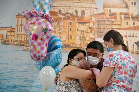 Klaudia Araraki et son mari heureux alors qu'ils récupèrent leur fils à l'hôtel Venise dans la capitale ukrainienne de Kiev le 10 juin 2020. Photo par SERGEI SUPINSKY / AFP via Getty Images.