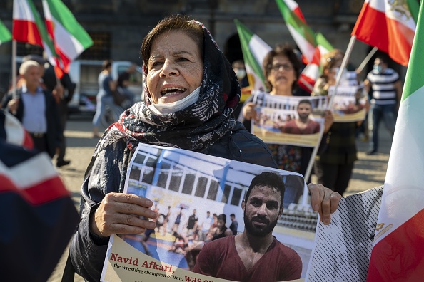 -Une femme tient un portrait du lutteur iranien Navid Afkari lors d'une manifestation sur la place du Dam à Amsterdam, aux Pays-Bas, le 13 septembre 2020. Photo par Evert Elzinga / ANP / AFP via Getty Images.