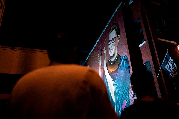 -Les personnes en deuil se rassemblent sous une peinture murale de la défunte juge de la Cour suprême des États-Unis, Ruth Bader Ginsburg, de l'artiste Rose Jaffe, à Washington, DC, à la fin du 18 septembre 2020. Photo par Alex Edelman / AFP via Getty Images.