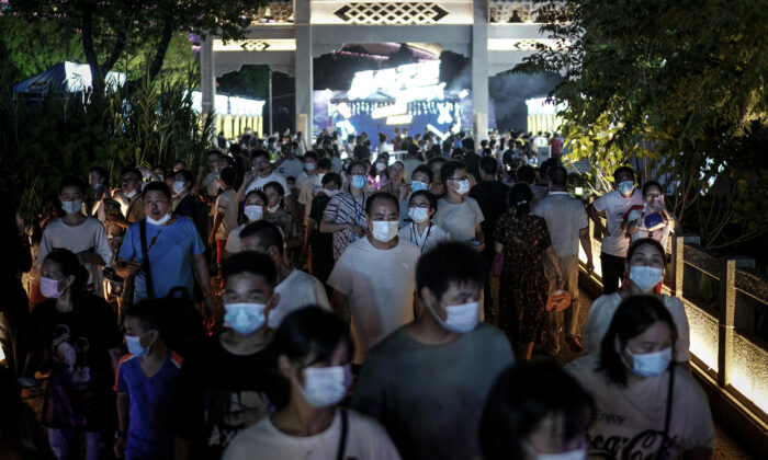 Des habitants portent des masques lorsqu'ils traversent l'entrée du festival de la bière de Wuhan dans la ville de Wuhan, province du Hubei, en Chine, le 21 août 2020. (Getty Images)