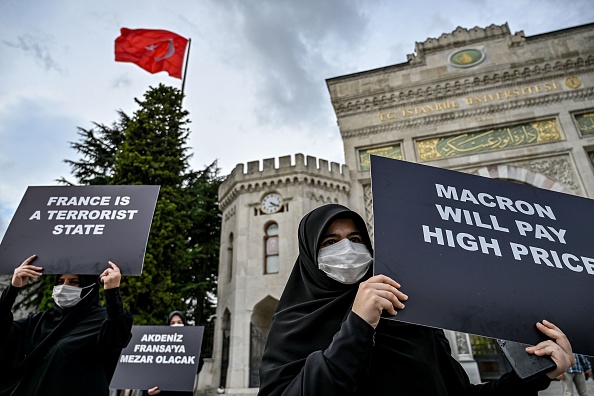 Le 13 septembre 2020, des Turcs brandissent des pancartes hostiles à la France dans le cadre d’une manifestation organisée à Istanbul contre la republication des caricatures du prophète Mahomet par Charlie Hebdo à l’occasion de l’ouverture du procès des attentats islamistes dont l’hebdomadaire satirique a été victime le 7 janvier 2015. Crédit : OZAN KOSE/AFP via Getty Images.