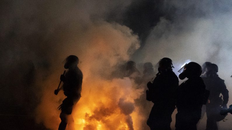 Des agents de la police étatique de l'Oregon et de la police de Portland avancent à travers les gaz lacrymogènes tout en confrontant les manifestants à Portland, Oregon, le 5 septembre 2020. (Nathan Howard/Getty Images)
