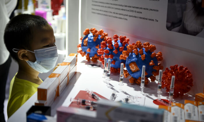 Un garçon regarde la présentation du vaccin candidat de Sinovac Biotech LTD contre le coronavirus Covid-19 à la Foire internationale du commerce des services de Chine (CIFTIS) à Pékin, en Chine, le 6 septembre 2020. (NOEL CELIS/AFP via Getty Images)