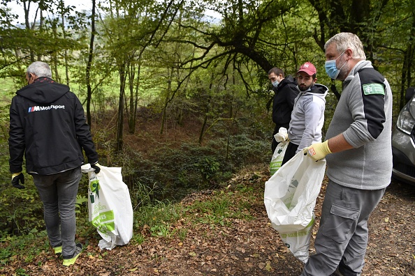 Un policier de l'environnement (à droite) encadre un groupe près du lac d’Aiguebelette en Savoie afin de ramasser des déchets lors d'un stage de citoyenneté. (PHILIPPE DESMAZES / AFP) (Photo by PHILIPPE DESMAZES/AFP via Getty Images)