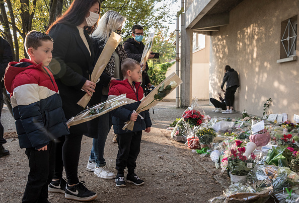 Une famille se recueille à l'entrée du collège Bois d'Aulne le 17 octobre 2020 de Conflans-Sainte-Honorine. (Photo Siegfried Modola/Getty Images)