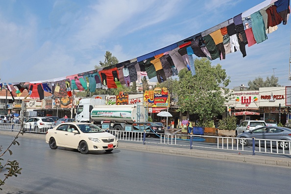 -Des voitures passent sous une œuvre d'art de l'artiste plasticienne irakienne Tara Abdallah, suspendue au-dessus d'une autoroute dans la région autonome kurde du nord de l'Irak, le 26 octobre 2020. Photo par Shwan Mohammed / AFP via Getty Images.