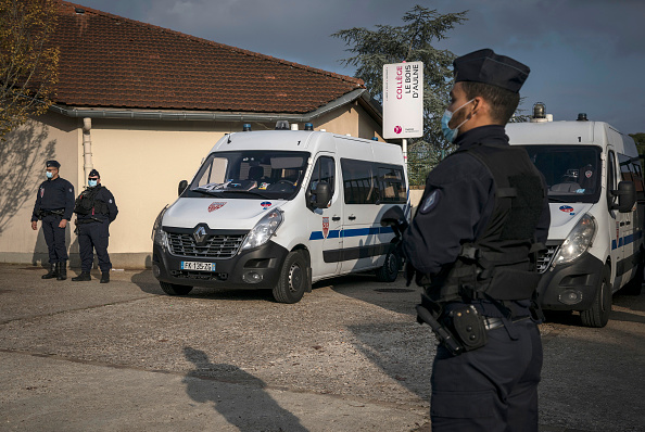 Des policiers sont en faction devant le collège du Bois d’Aulne de Conflans-Sainte-Honorine au lendemain de l’assassinat barbare de Samuel Paty par un islamiste russe d’origine tchétchène qui bénéficiait du statut de réfugié. Crédit : Siegfried Modola/Getty Images.