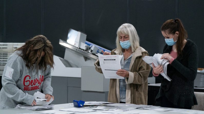 Le personnel électoral trie les demandes de vote par correspondance pour les stocker au bureau du Conseil du comté de Gwinnett pour l'inscription des électeurs et les élections à Lawrenceville, Géorgie, le 7 novembre 2020. (Elijah Nouvelage/Getty Images)