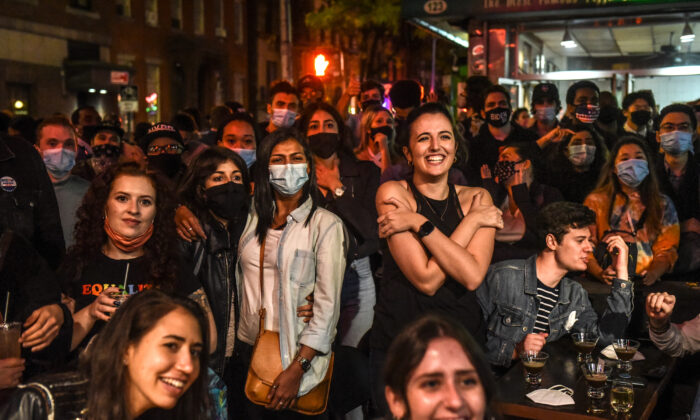 Les partisans du candidat démocrate américain Joe Biden regardent un programme diffusé, dans le West Village de New York le 7 novembre 2020. (Stephanie Keith/Getty Images)