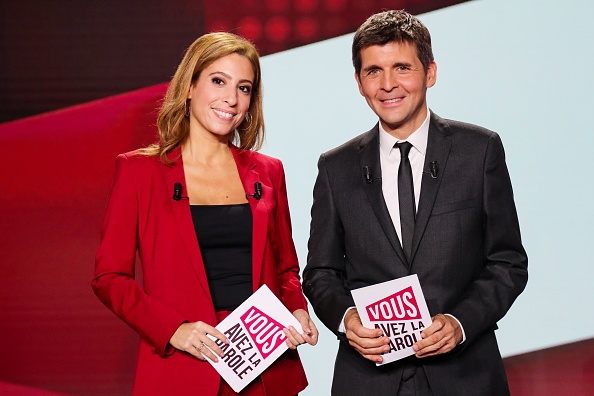 Les journalistes français Lea Salame (à gauche) et Thomas Sotto (à droite) posent avant le début de l'émission politique qu'ils animent "Vous avez la parole", sur le plateau de France 2  (JACQUES DEMARTHON/AFP via Getty Images)