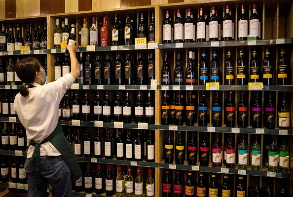 -Une employée installe du vin de fabrication australienne sur les présentoirs dans un magasin de Pékin le 18 août 2020. Photo par Noel Celis / AFP via Getty Images.