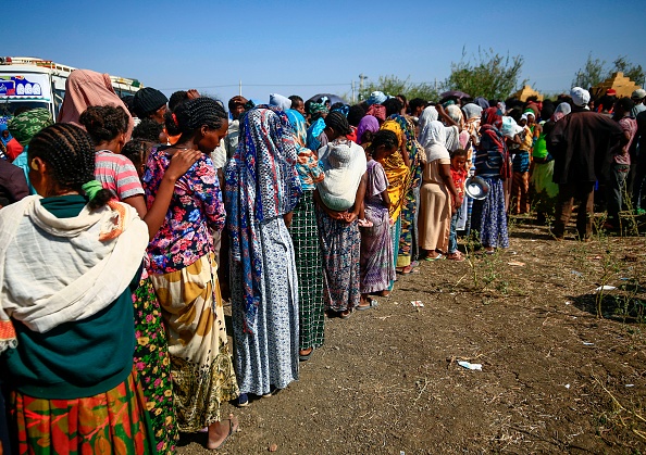 -Les réfugiés éthiopiens qui ont fui les combats dans la région du Tigray se rassemblent au centre d'accueil frontalier du Village 8 dans l'est du Soudan, le 20 novembre 2020. Photo par Ashraf Shazly / AFP via Getty Images.