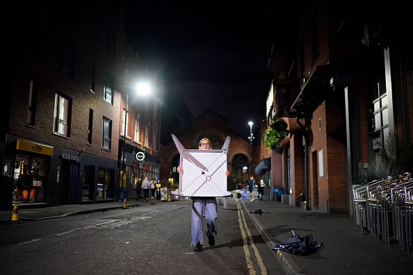 -Le personnel du bar débarrasse les tables et les chaises à la veille des nouvelles restrictions Tier-3 Covid-19 le 22 octobre 2020 à Manchester, en Angleterre. Photo par Christopher Furlong / Getty Images.