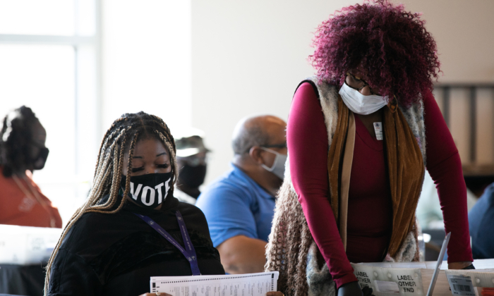 Les travailleurs du comté de Fulton continuent à compter les bulletins de vote par correspondance à la State Farm Arena le 6 novembre 2020 à Atlanta, en Géorgie. La course présidentielle de 2020 entre le président sortant des États-Unis, Donald Trump, et le candidat démocrate, Joe Biden, est encore trop serrée pour désigner un vainqueur avec des bulletins de vote en souffrance dans un certain nombre d’États, dont la Géorgie. (Jessica McGowan/Getty Images)